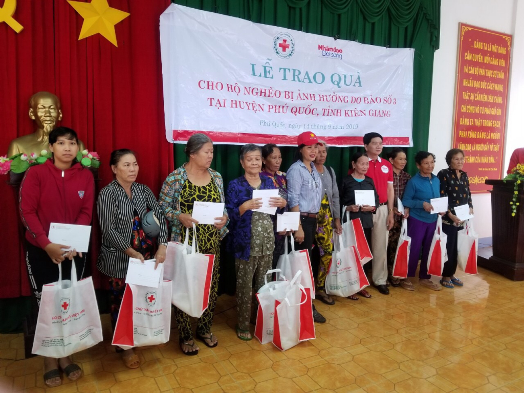 Bà Trần Thị Định Tổng giám đốc CTCP Địa ốc Thiên Sứ (Người đội mũ đỏ) đang tặng quà