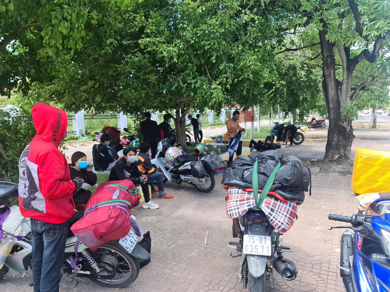 Người dân về từ các tỉnh phía Nam nghỉ trưa ven đường Ql 1A